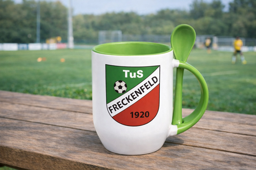 Weiße Two-Tone Löffeltasse mit farbigem Henkel und integriertem Löffel, bedruckt mit einem Logo, steht auf einem Tisch